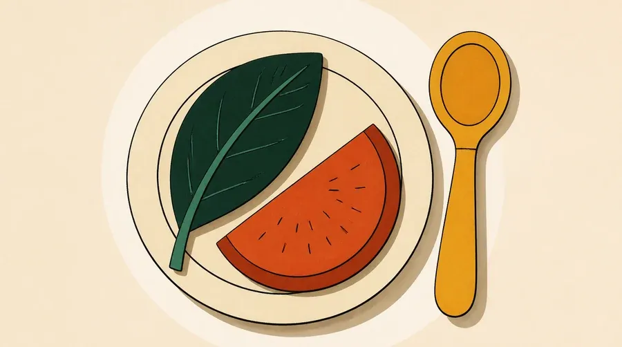 Assiette crème avec feuille vert forêt, fruit terre cuite et cuillère ocre.