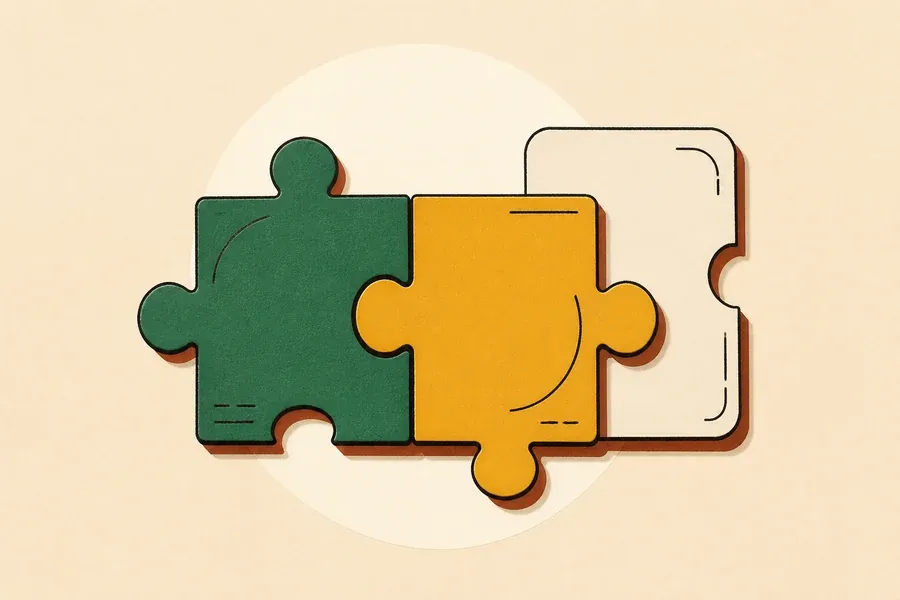 Pièces de puzzle sauge et ocre, carte crème posée près.