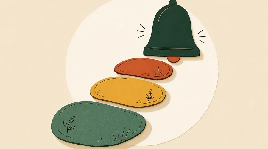 Trois galets colorés mènent vers une cloche vert forêt.
